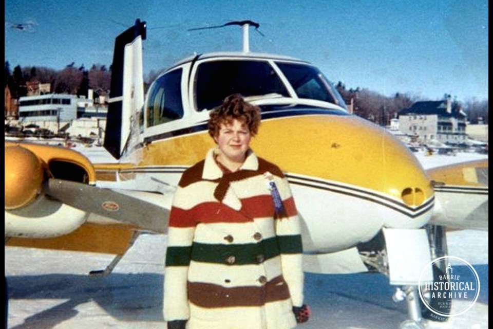 A woman posing with a plane during the 1968 Winter Carnival. Photo provided by Barrie Historical Archive