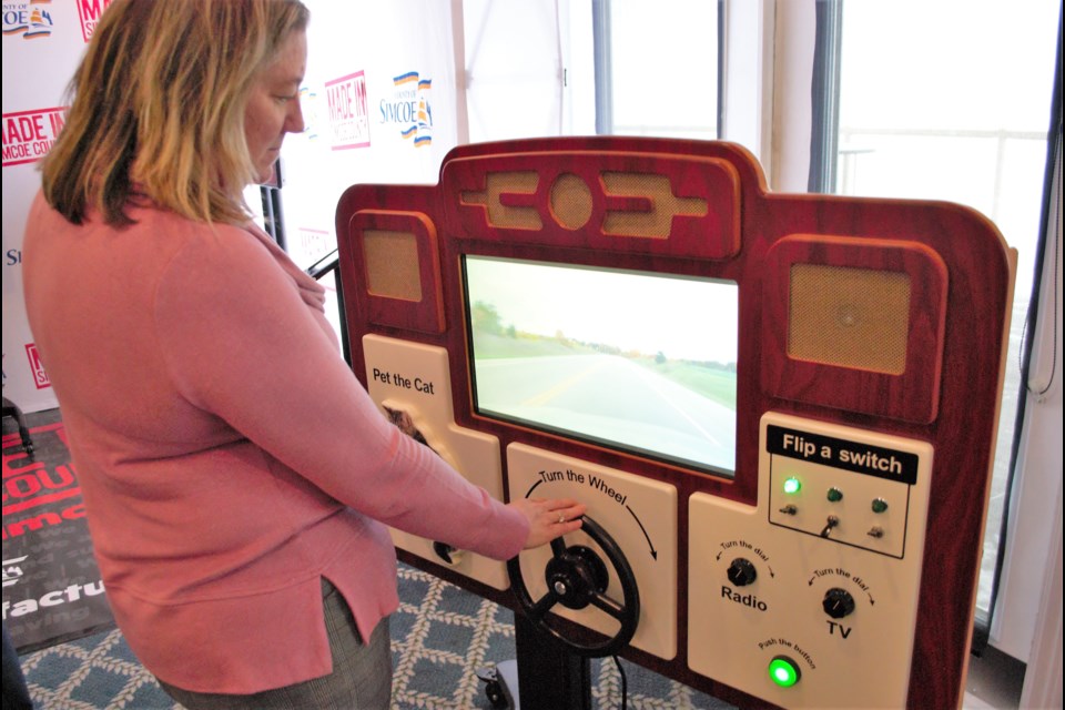 Michelle Cooper, senior account manager at BDC in Barrie, tests out ABBY, a device that offers ambient experiences for dementia patients. ABBY is manufactured by Ambient Activity in Midland. Jessica Owen/BarrieToday