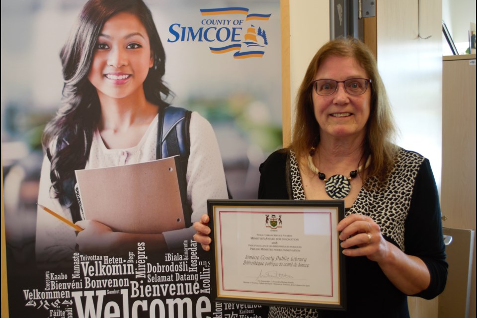 Gayle Hall, chief librarian and CEO of the Simcoe County Library Co-operative, shows off the award the co-operative received for their Simcoe County Libraries Immigrant Hub project. Jessica Owen/BarrieToday