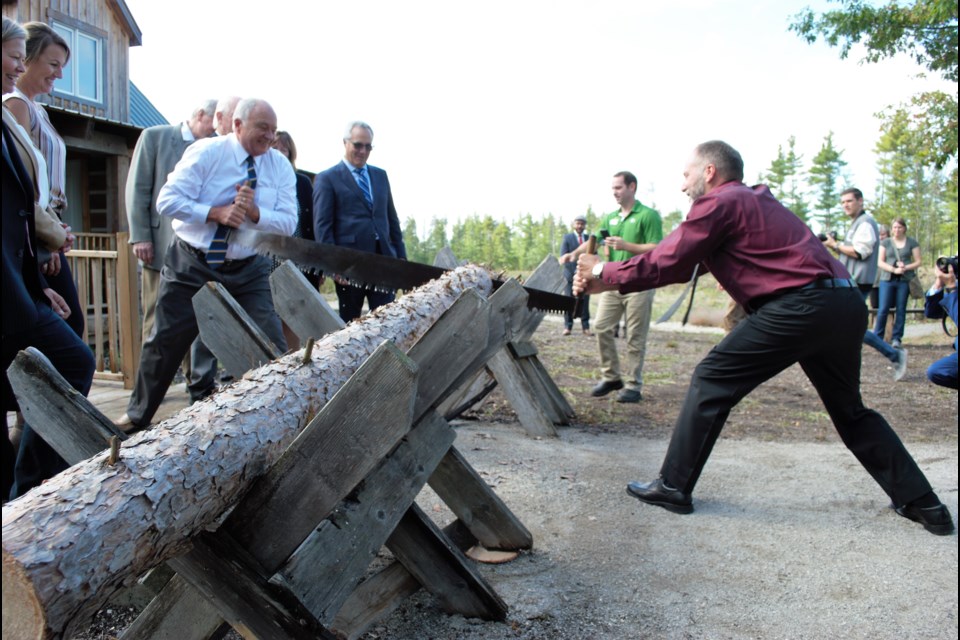 Simcoe County Warden George Cornell and county forester Graeme Davis cut the log (instead of cutting the ribbon), signalling the opening of The Red Pine House, a forestry education centre on the Simcoe County Museum property. Jessica Owen/BarrieToday