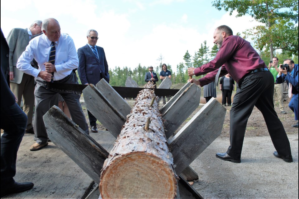 Simcoe County Warden George Cornell and county forester Graeme Davis cut the log (instead of cutting the ribbon), signalling the opening of The Red Pine House, a forestry education centre on the Simcoe County Museum property. Jessica Owen/BarrieToday