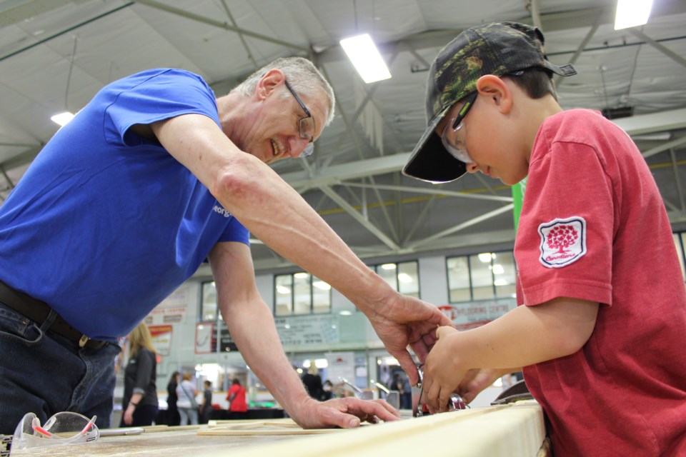 Mitchell Parsons, a 10-year-old Barrie boy, gets some help from Phil Leboeuf, program manager from Georgian College's Midland campus, at the 2018 Simcoe Muskoka Skilled Trades Expo in Elmvale, Thursday evening. Raymond Bowe/BarrieToday