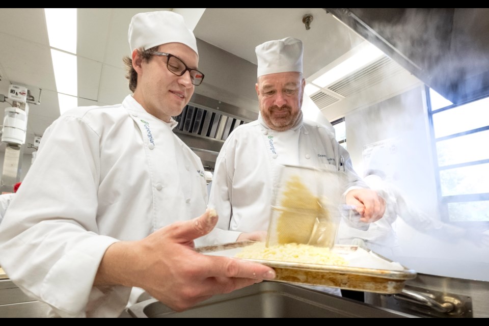 First-year Georgian College Culinary Management students Don Scandrett (right) and Brent Zacs put some finishing touches on the lunch preparations for Qualification Level 3 Reserve Cook Course students and faculty at Canadian Forces Base Borden on July 10. (Georgian College / Doug Crawford)