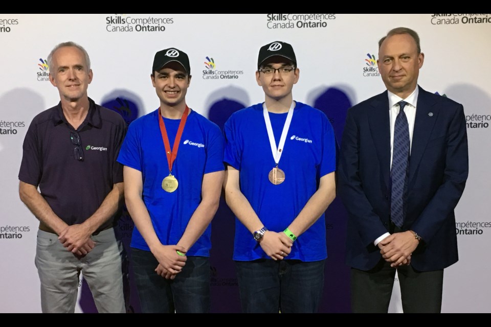 Georgian College CNC Precision Skills students Andrew Pittman, second from left, won gold at the Skills Ontario competition May 3. Teammate Augusto Marzinotto won bronze. Accompanying them are faculty coach Jurgen Hierholzer, left, and Dan Ferko of the Gene Haas Foundation, a generous donor to Georgianâs CNC program.