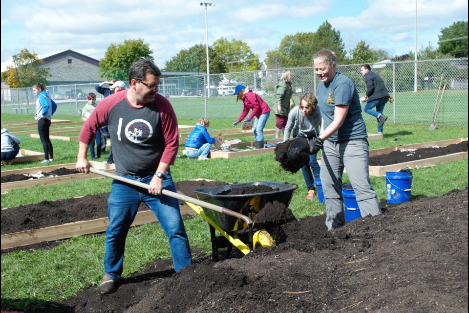 Volunteers work together to fill in the 21 new community garden beds at Eastview Park on Saturday. Jessica Owen/BarrieToday
