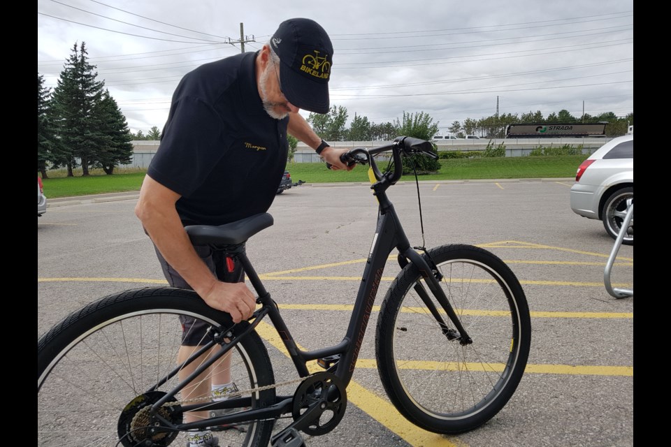 With Highway 400 in the background, Bikeland owner Morgan Lemen checks out one his more popular bikes, Friday Sept. 13, 2019. Shawn Gibson/BarrieToday