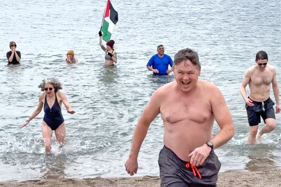 Michelle Emond, of Bradford, bottom left, exits as fast as she can as she takes part in the Polar Plunge for Palestine fundraising event at Centennial Beach in Barrie on April 20.