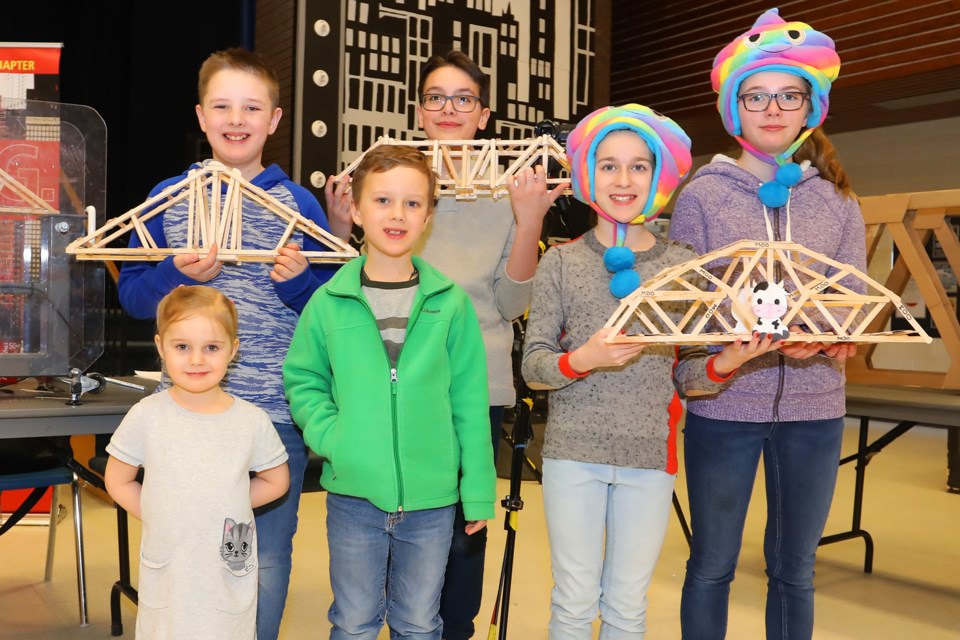 Tirso Pinilla, Finlay Lemon, Ryder Lemon, Chiara Lemon, Myanna Cox, and Cara Lintack show off their homemade bridges during a National Engineering Month event at Eastview Secondary School hosted by the Professional Engineers of Ontario and OACETT on Saturday, March 3, 2018. The event introduced children to the world of engineering with competitions in popsicle stick Bridge, catapult and mechanical grabber for grade 5-8 students. Kevin Lamb for BarrieToday.