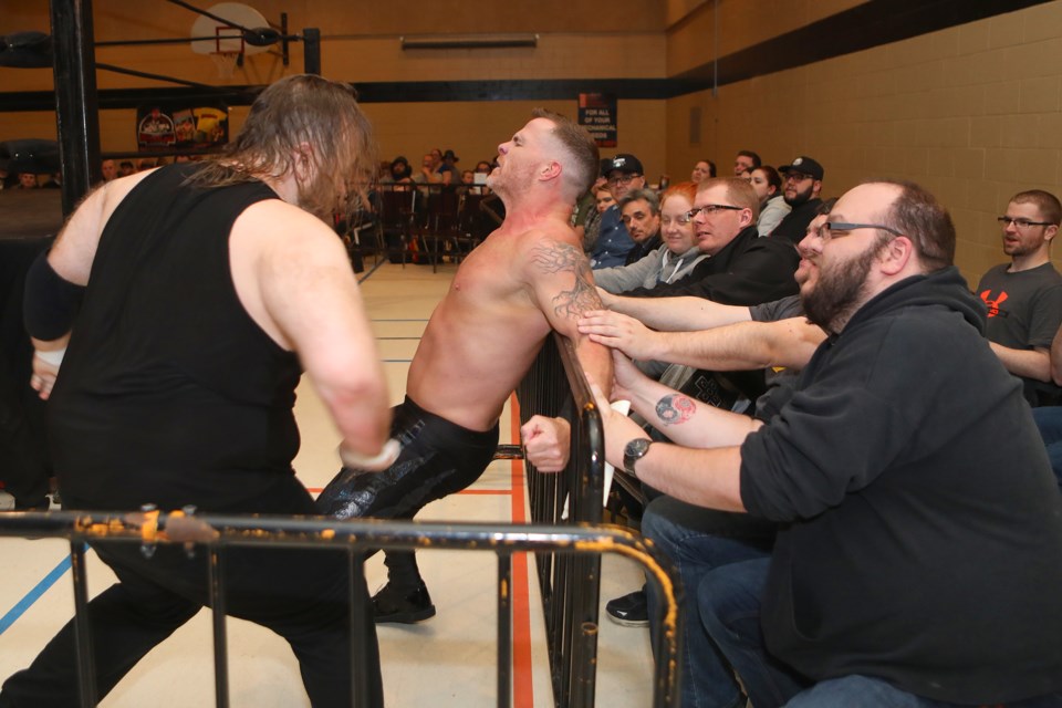 Fans help out John Greed by holding down heavyweight champion Tyson Dux outside of the ring during a Barrie Wrestling event. Dux is among those expected to wrestle in Orillia later this year. Kevin Lamb for OrilliaMatters.