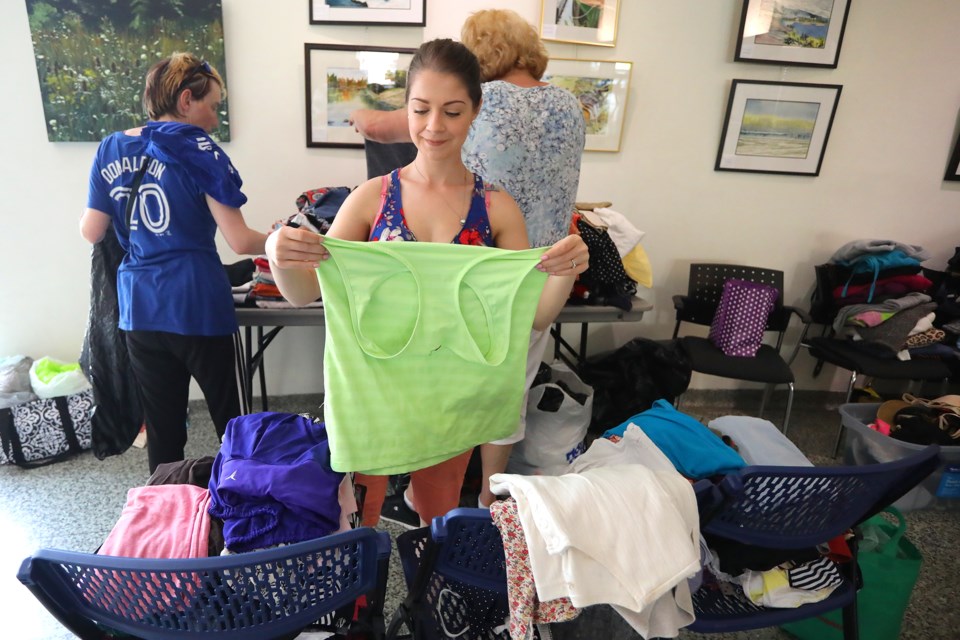Volunteer Anna Sedore folds clothing as Friends of the Homeless held an event that gave the homeless in Barrie some much needed food, clothing, and other supplies at City Hall on Saturday, May 26, 2018. Kevin Lamb for BarrieToday.