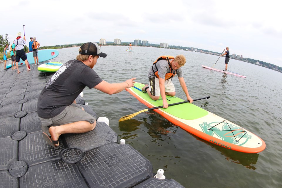 Noel Furniss of Pulse Stand-Up Paddle Boards instructs a visitor to the Barrie Canoe and Kayak Club as it held its open house at their boathouse at the Southshore Community Centre on Saturday, July 14, 2018. Kevin Lamb for BarrieToday.