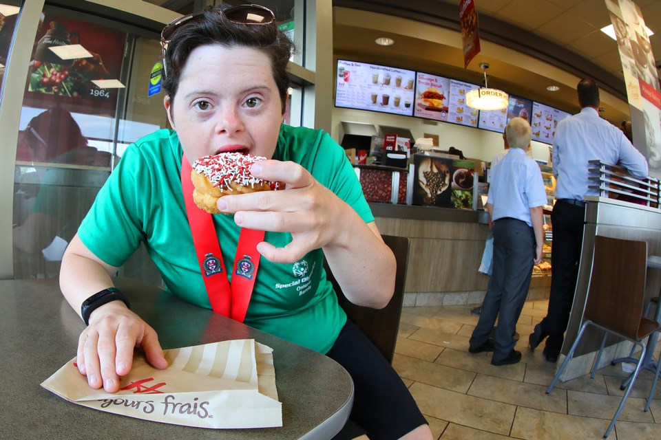 Athlete Fiona Fryer, while visiting the Tim Hortons on Huronia Road, tries out the new donut on offer for Saturday, July 21, 2018 as Tim Hortons celebrated the 50th anniversary of Special Olympics with a limited edition donut with all proceeds going to Special Olympics programs across the country. Kevin Lamb for BarrieToday.