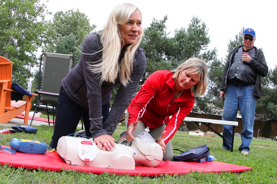 Carly Jackson and her mother Patty demonstrate how to perform CPR and use an AED (automated external defibrillator) at their family home in Utopia. They have installed a unit on the exterior wall of their house for use by all in their small community. Everyone in their neighbourhood was invited to take part in the crash course on Sunday, September 9, 2018. Kevin Lamb for BarrieToday.