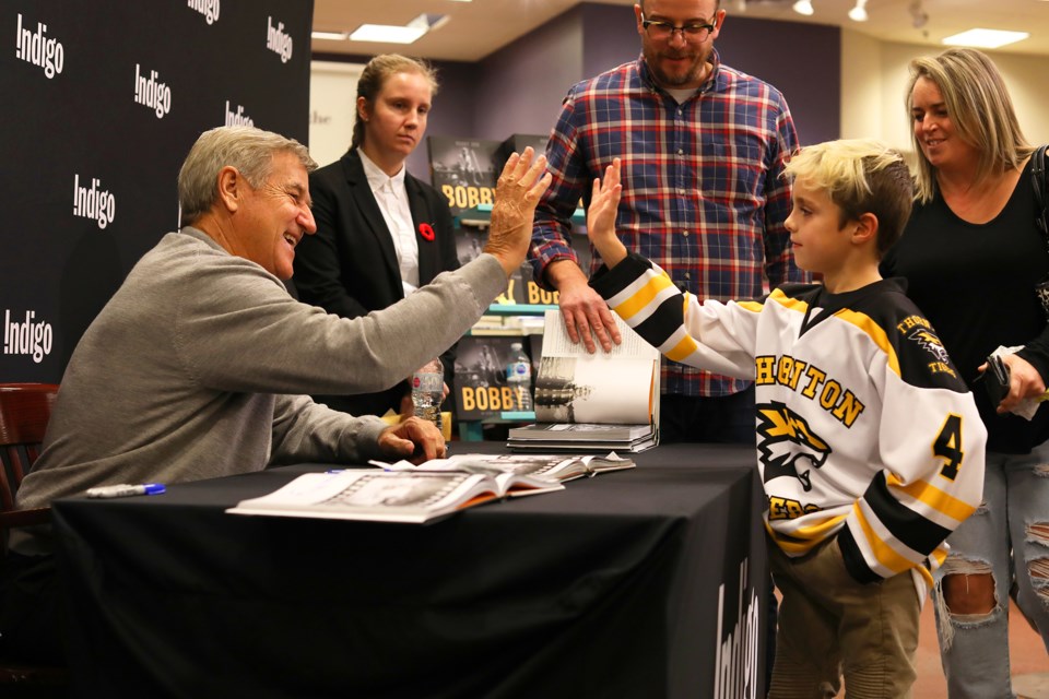 Seven-year-old Sheldon Desloges, a player with the Thornton Tigers, high fives NHL great Bobby Orr at Chapters in Barrie on Thursday, November 1, 2018. Kevin Lamb for BarrieToday.