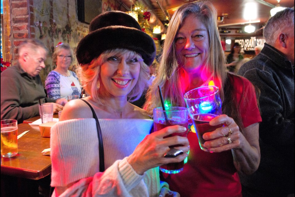From left, Debbie Mayor Lonsdale and Jackie Longstaffe enjoy a drink while listening to the band at Queen's Nightclub on Saturday. Jessica Owen/BarrieToday