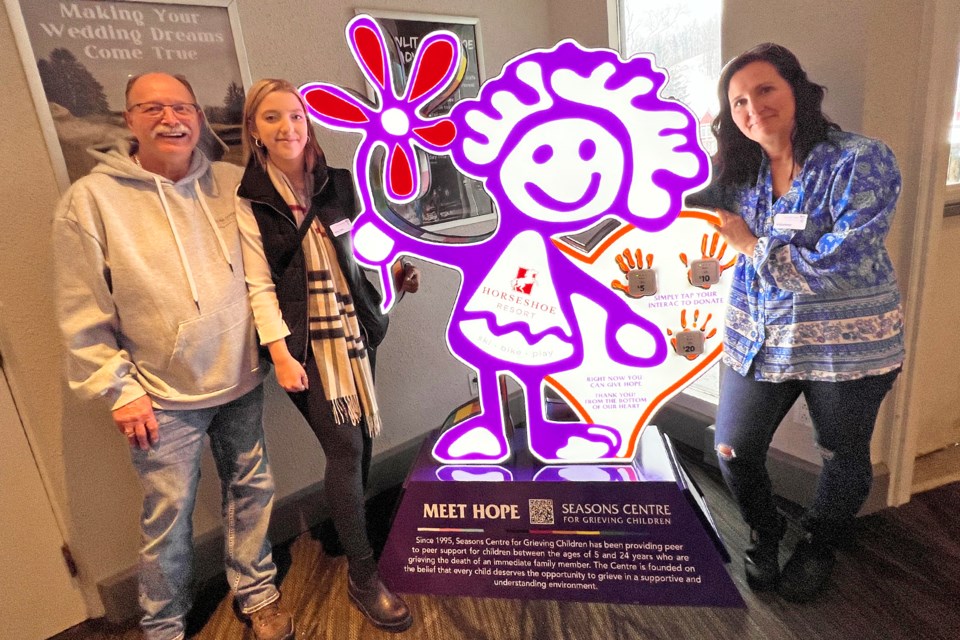 Rowley Ramey, left, is shown with volunteers Hailey Pride, centre, and Carlayne Gilbertson as they show off Hope, the mascot for Seasons Centre for Grieving Children, which hosted its inaugural Hope Around Town snow-tubing event at Horseshoe Resort on Saturday.