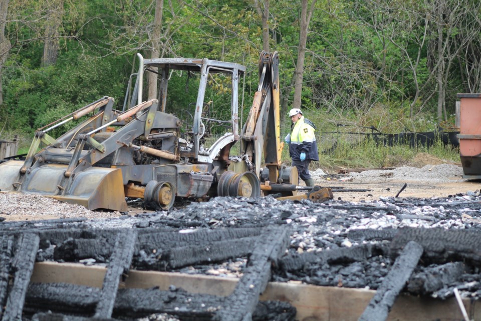 Fire investigators take a closer look at a burnt-out backhoe on June 10, 2019 following an overnight blaze on Edgehill Drive in west-end Barrie. Raymond Bowe/BarrieToday