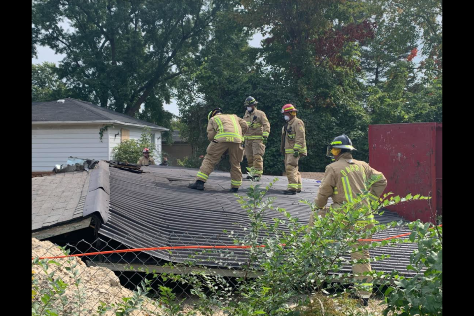 Barrie firefighters cut access holes in the roof following a structure collapse at a house on Yonge Street in south-end Barrie, Saturday afternoon. Raymond Bowe/BarrieToday