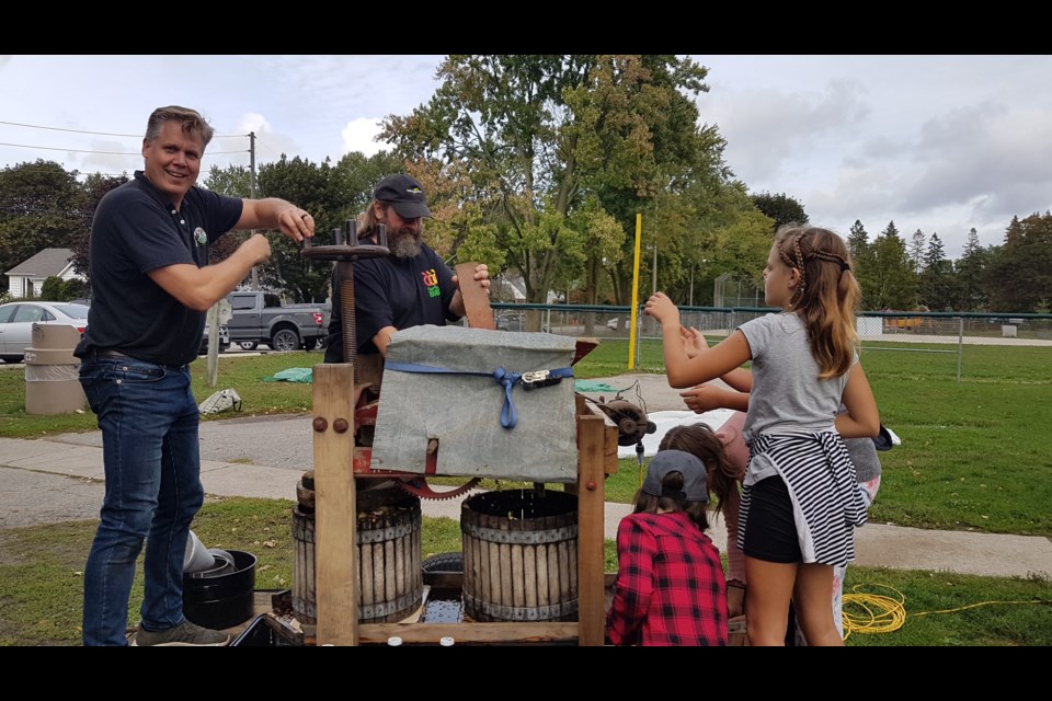 Barrie-Springwater-Oro-Medonte Green Party candidate Marty Lancaster (left) brought out his vintage juice press to make cider for everyone at Shear Park in Barrie on Saturday. Photo supplied