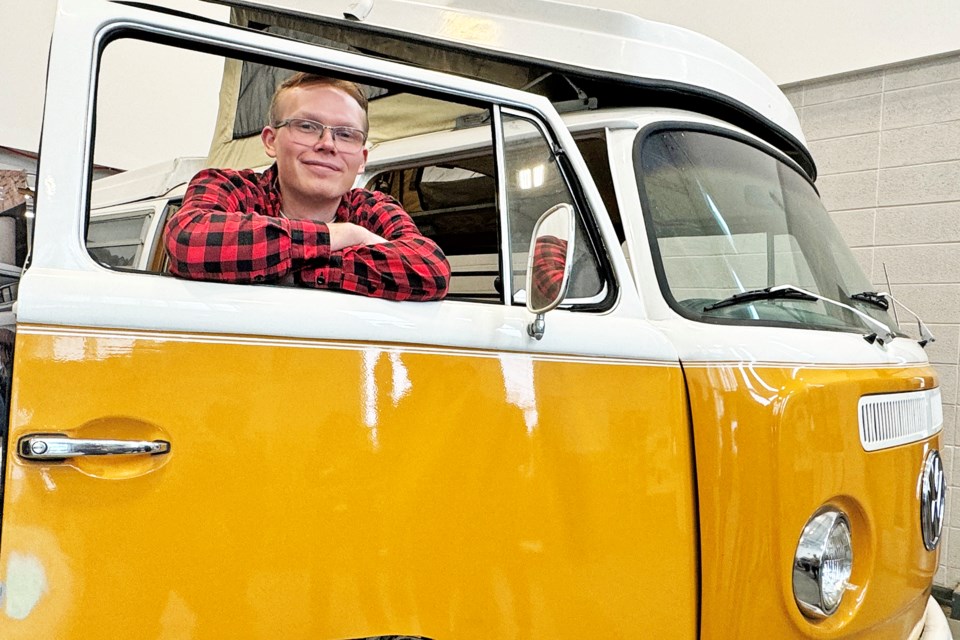 Georgian College mechanical engineering technology student Joshua Reitzel with the 1972 Volkswagen Westfalia he will be working on as part of an electric vehicle conversion project.