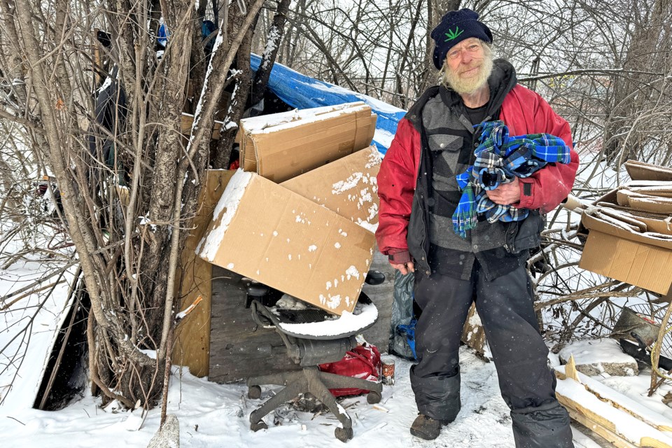 Rick, 75, stands outside his makeshift home near Anne and Victoria streets in Barrie on Tuesday.