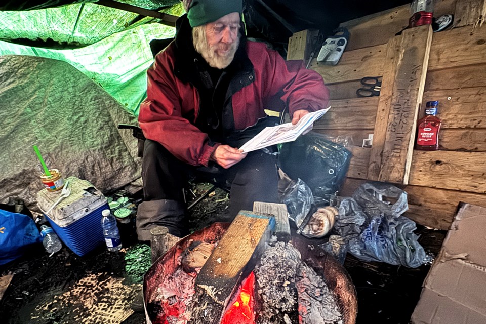 Rick, 75, reads a BarrieToday story about his plight at an encampment near Victoria and Anne streets in Barrie on Jan. 25.