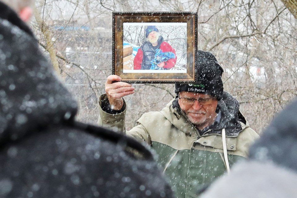 Jack deWinter, of Life Patrol outreach with New Life Fellowship Baptist Church in Innisfil, holds a BarrieToday photograph of Rick "The Mayor" Chenery during a memorial for the well-known homeless man who died last month. The service was held at Milligan's Pond, near the city's downtown, on Sunday, March 17.