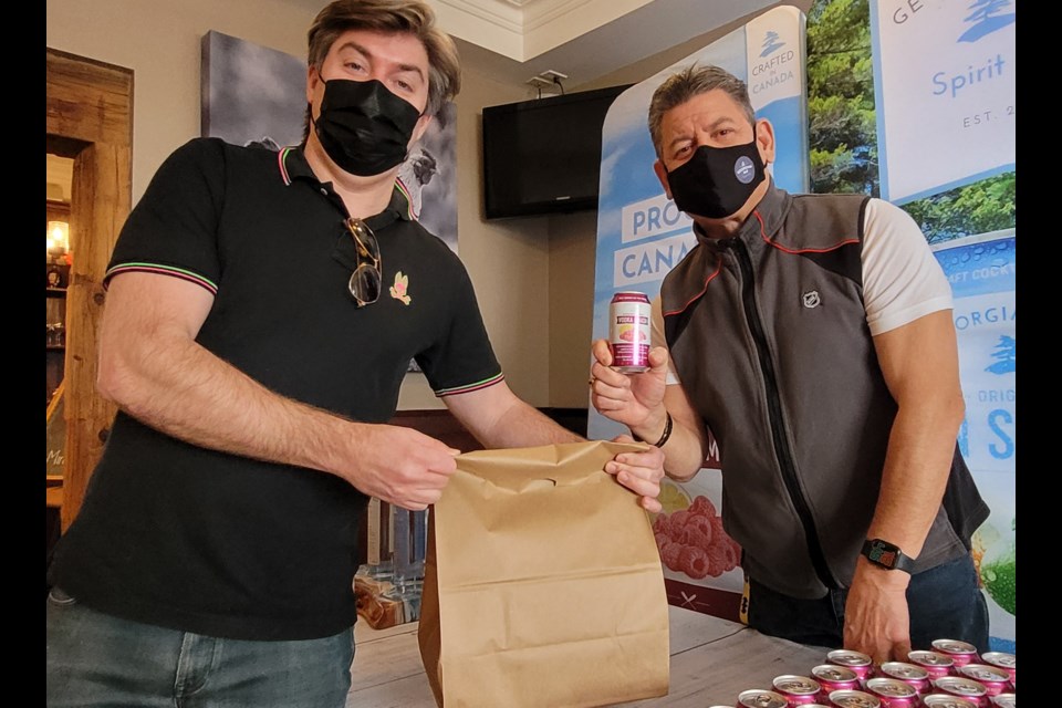 The Farmhouse Restaurant owner Randy Feltis (left) and Muskoka territory manager for Georgian Bay Spirit Co., Tony King, get lunch packages together for restaurant workers.