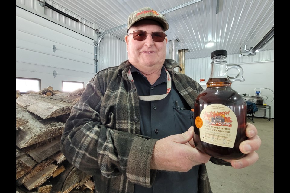 Orval Hutchinson shows off some of his family's maple syrup.