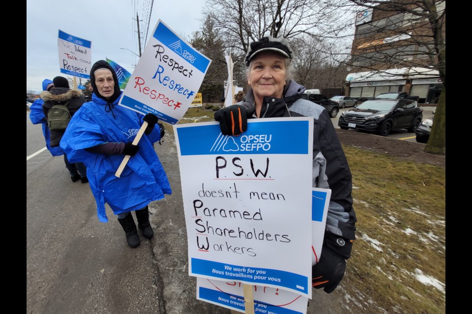 OPSEU/SEFPO Local 393 vice-president Lynne Reilly holds a sign showing her thoughts during a protest in Barrie on Wednesday.