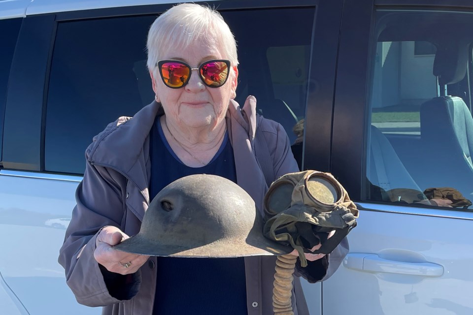 Barrie's Erica Hudell holds a bullet-damaged First World War helmet and gas mask which belonged to her father-in-law, George Hudell. She recently donated the items to CFB Borden's museum.