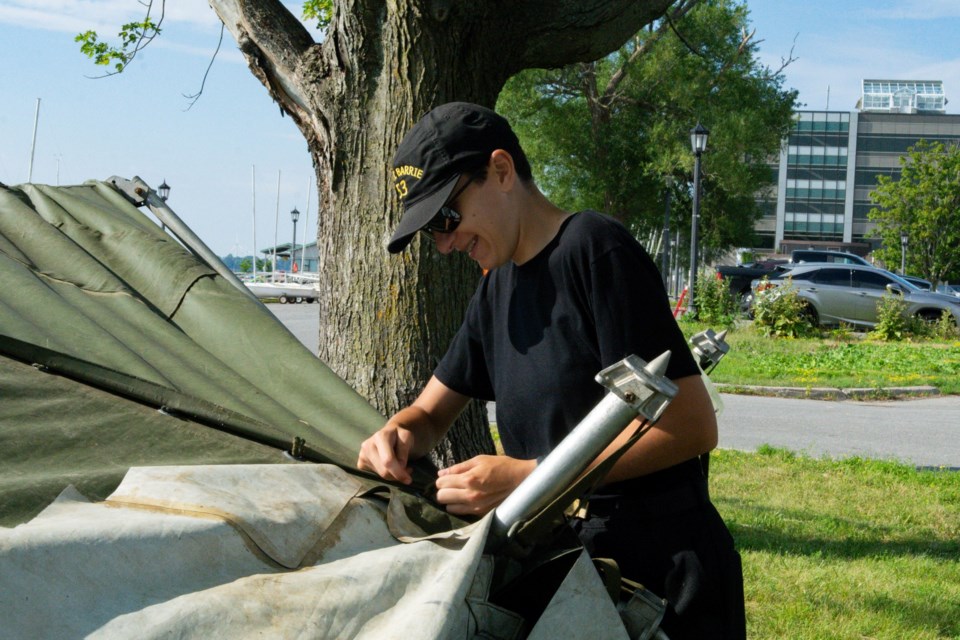 Talia Rossit, the boatshed Senior Cadet for the Sail 1 course of summer 2022, disassembles a tent that was blown away.