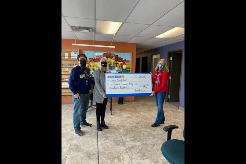 Shawn Gibson and Kim Black from BarrieToday bring a cheque to Sharon Palmer,  Executive Director of the Barrie Food Bank, just in time for the holidays.