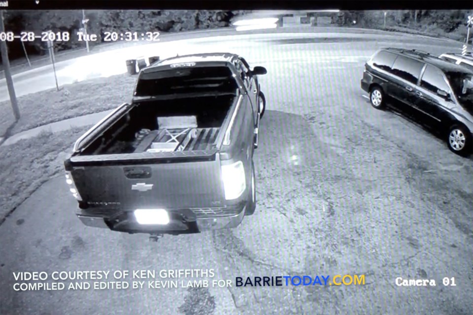 Security video footage shows a Tesla getting airborne, blurred at top centre of screen with shadow on road underneath, before losing control and crashing into the parking lot of Assikinack Public School. Kevin Lamb for BarrieToday