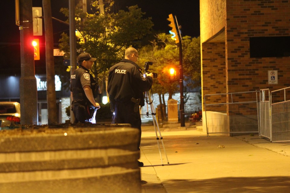 Barrie police officers document the crime scene at Collier and Clapperton streets following a stabbing downtown, Friday night. Police believe it was a targeted attack. Raymond Bowe/BarrieToday