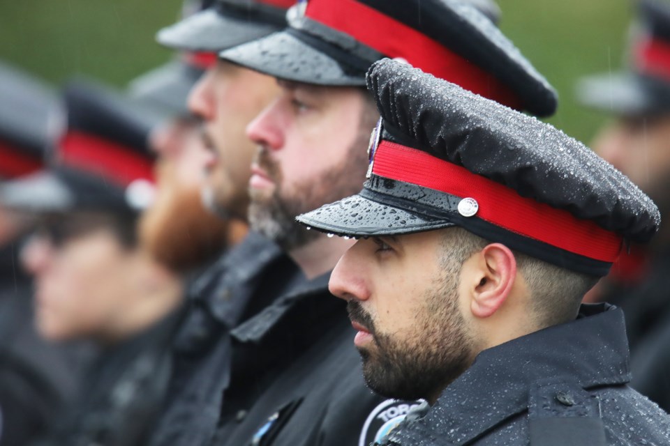 Toronto police officers wait along the parade route in Barrie for the funeral of OPP Const. Greg Pierzchala on Wednesday, Jan. 4, 2023.