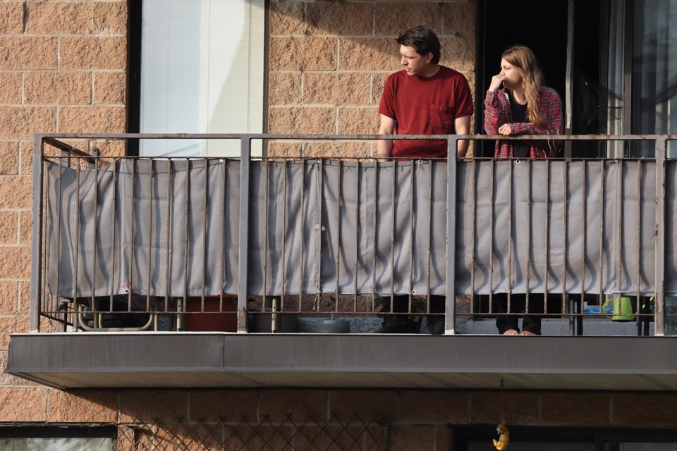 Residents watch police activity from their balcony during an explosives investigation at 108 Anne St. N., in Barrie, on Wednesday, Sept. 27, 2023.