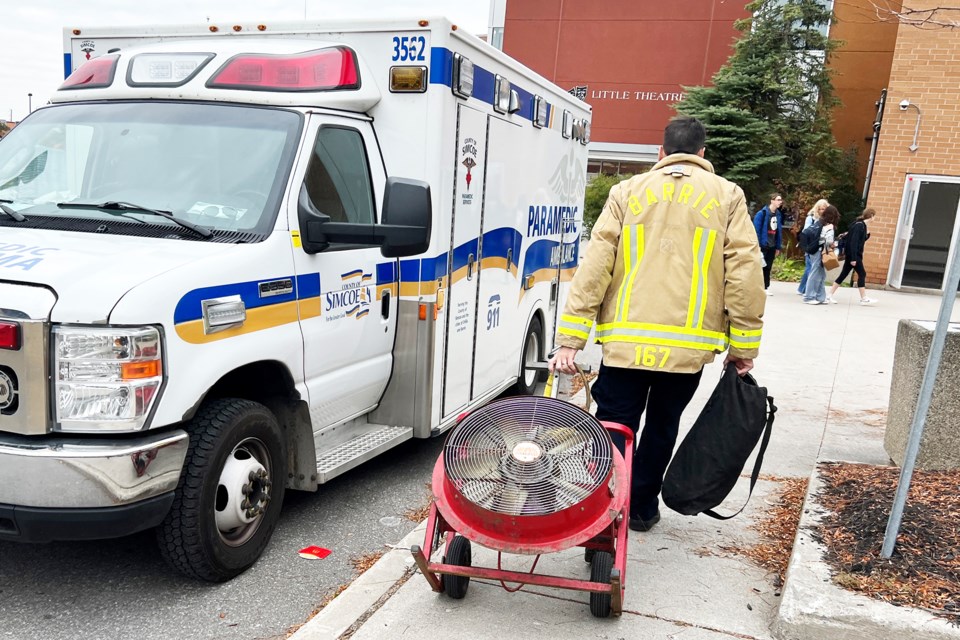 A firefighter pulls a fan used to ventilate the building after a noxious substance was released at Innisdale Secondary School on Wednesday morning. A suspect was arrested a short time later.
