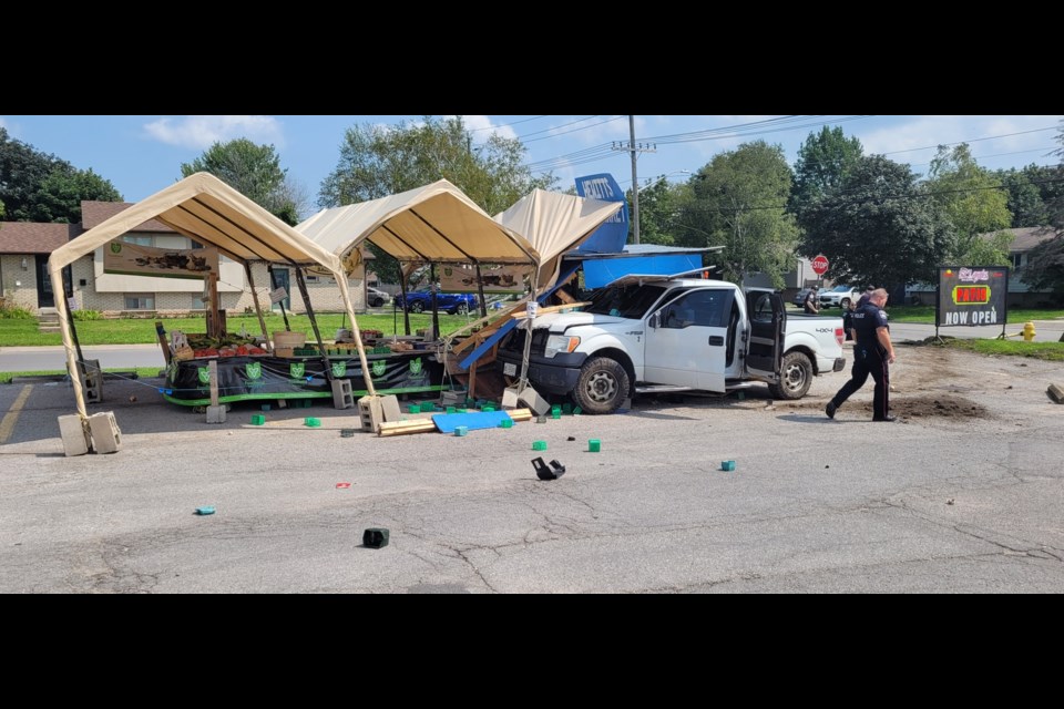 In attempting to flee a motor vehicle collision this afternoon, a truck collided with a local farm stand at a plaza on Duckworth and Grove Streets.