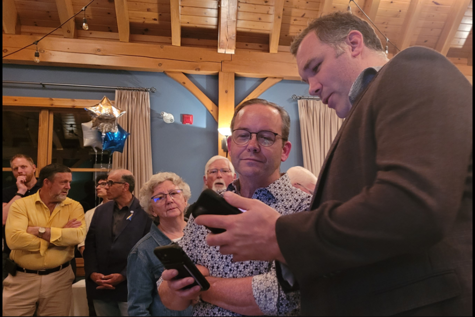 Former Barrie-Springwater-Oro-Medonte MP and current Barrie mayoral hopeful Alex Nuttall (right) shows Doug Downey the latest poll results during last night's provincial election. Downey, the incumbent in the riding, defeated Liberal candidate Jeff Lehman by 609 votes. 