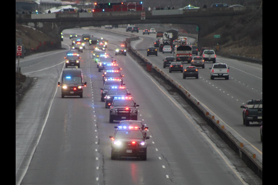The procession escorting Const. Grzegorz Pierzchala along Highway 400 North heads toward the Bayfield Street overpass Friday.