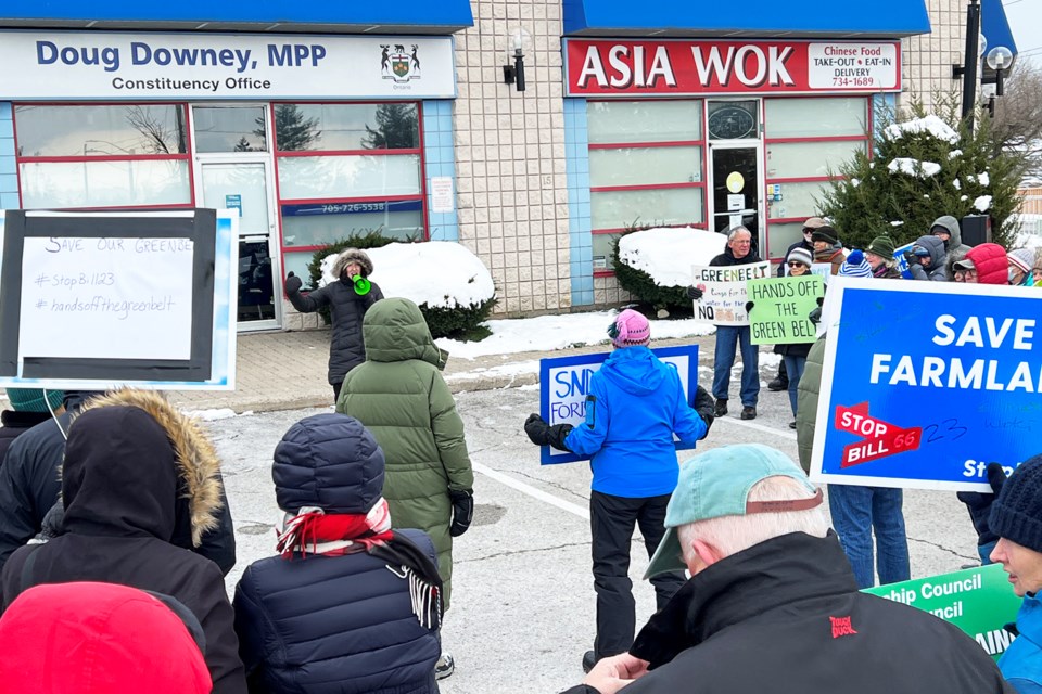 Protesters rally in front of Barrie-Springwater-Oro-Medonte MPP Doug Downey's constituency office on Bell Farm Road in Barrie on Saturday.