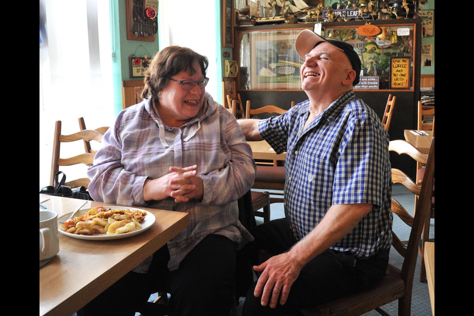 Fil Triantafillou, owner of Fil's Cafe in Barrie's east end, adds some fun times to the food of customer Bonnie Tasarich. He's been operating the eatery at Grove and Duckworth streets since 1983. Ian McInroy for BarrieToday