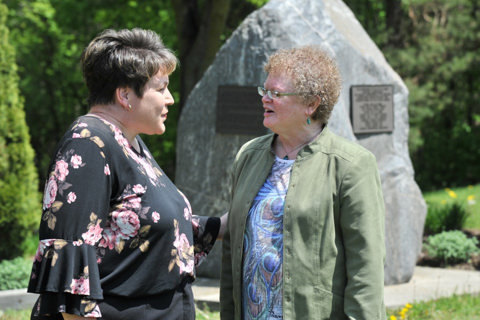 Crystal Poechman-Colville, left, who lost a sibling during the devastating Barrie tornado of 1985, speaks with Judith Banville, who will be presenting her 2015 documentary DVD The Barrie Tornado Remembered at Grace United Church Friday evening. Behind them is a memorial in Shear Park remembering those who perished or were injured during the tornado as well as the efforts of emergency crews and residents. Ian McInroy for Barrie Today