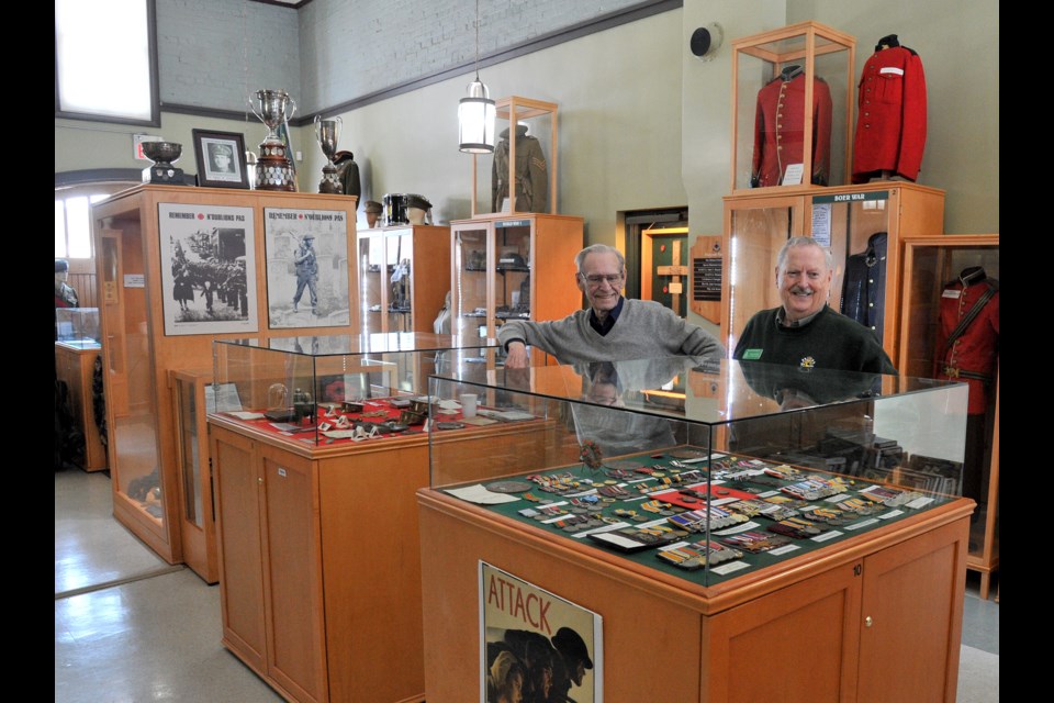 Grey & Simcoe Foresters Maj. Peter Litster (Ret.) CD, right, curator of the Grey & Simcoe Foresters Regimental Museum, looks at wartime medals on display in the Mulcaster Street facility with Lt. Col. (Ret.) Lorne Williams. Ian McInroy for BarrieToday