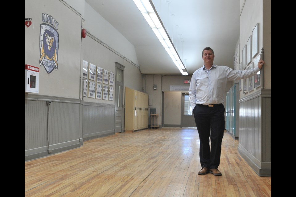 Unity Christian High School principal Allen Schenk stands in the school’s main hallway, which features refurbished wood flooring from the original Burton Ave. School, which was constructed in 1906.  Ian McInroy for BarrieToday