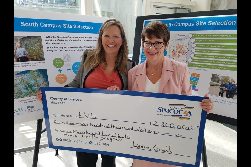 Innisfil Mayor Lynn Dollin (left) and Royal Victoria Regional Health Centre president and CEO Janice Skot stand in front of the plans for the health centre's south-end plans with a cheque from the county, Thursday Sept. 12, 2019. Shawn Gibson/BarrieToday