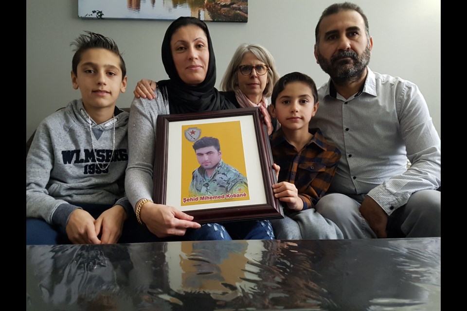 Left to right:Mahmoud (10), Shirin, Sarah Uffelmann, Fuad (70) and Mohamad pose with the photo of Shirin's younger brother, Hamoudi, who was recently killed in action in Syria. Shawn Gibson/BarrieToday