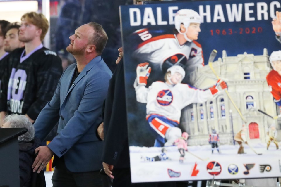 Dale Hawerchuk's son watches as a banner is raised to the rafters on Saturday night at Sadlon Arena to pay tribute to the former coach of the Barrie Colts, who passed away in 2020.