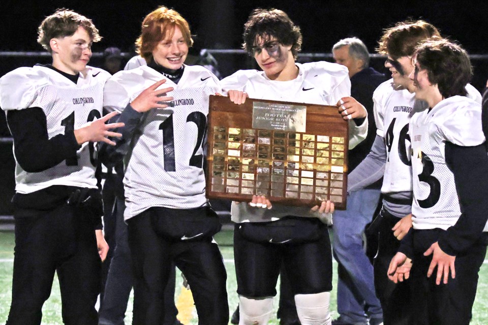 Collingwood Fighting Owls team captains accept the Georgian Bay Secondary School Association (GBSSA) junior football championship plaque after defeating Barrie's St. Peter's Panthers, 39-6, at J.C. Massie Field at Georgian College on Tuesday night.